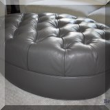 F03. Oval tufted leather ottoman 16”h x 45”w x 29”d 